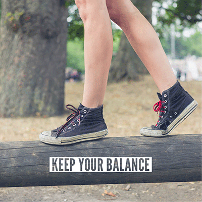 A photo of a child's feet balancing on a log