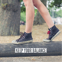 A photo of a child's feet balancing on a log