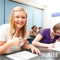 Young girl at a desk giving a thumbs up